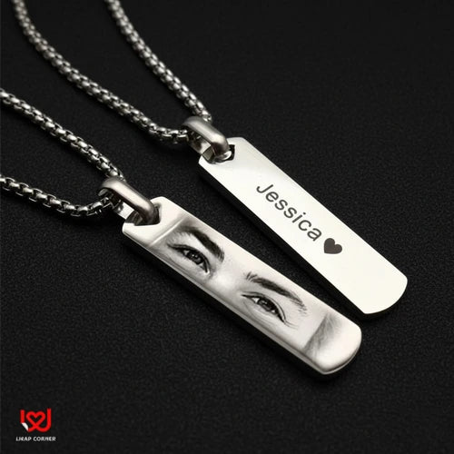 Two silver necklaces with engraved names on a black background