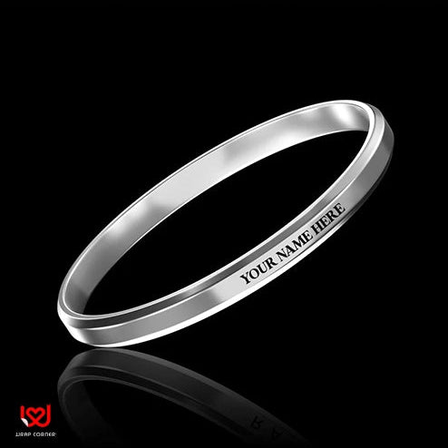 Silver bracelet with 'Your Name Here' engraving on a black background